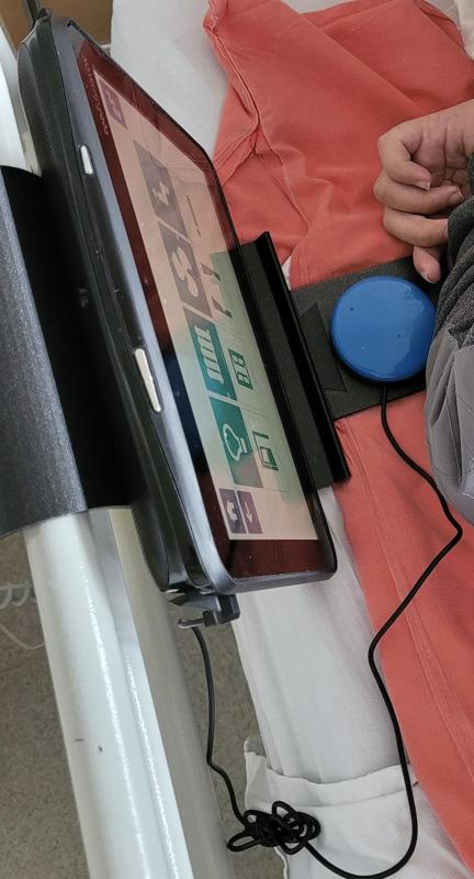 Support pour tablette de communication au lit pour une personne en situation de handicap