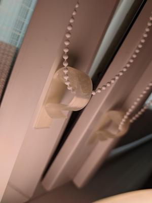 Vertical clip/tensioner for blind cord/chain