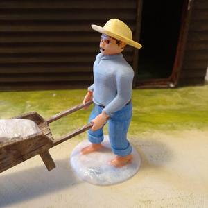 A 7cm saunier santon pushing a wheelbarrow of salt