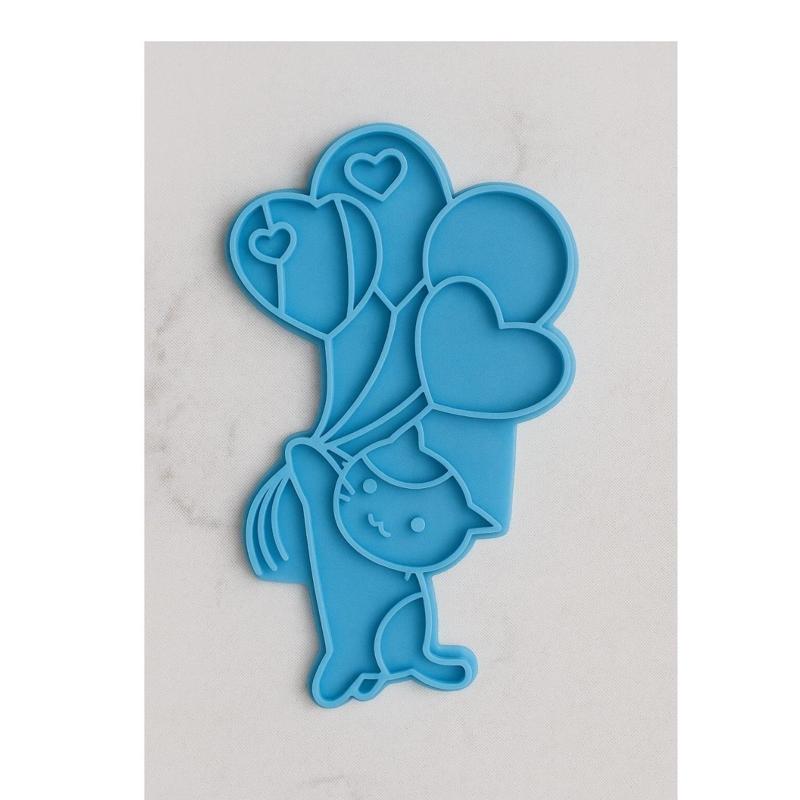 Cookie cutter of a kitten holding balloons