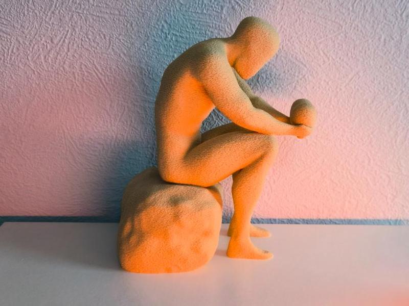Reflective Man – Seated Statue Holding a Heart