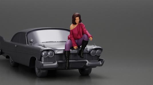 lowrider girl sitting on a car, wearing boots and a stylish shirt