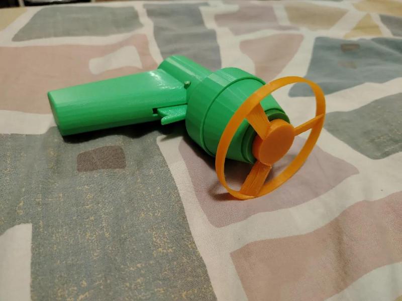 TOY GUN THAT SHOOTS FLYING TURNPINNERS   