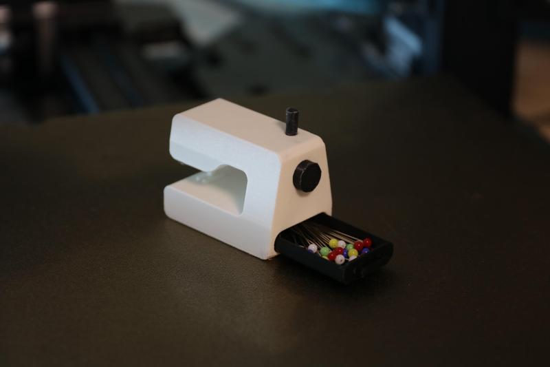 Miniature sewing machine with drawer for needles