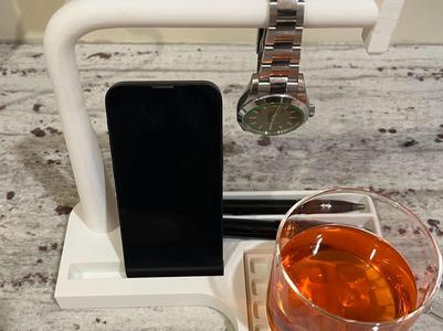 Desk caddy. Watch bar; slots: cup, phone, and pens