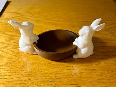 Two bunnies hanging on a bowl