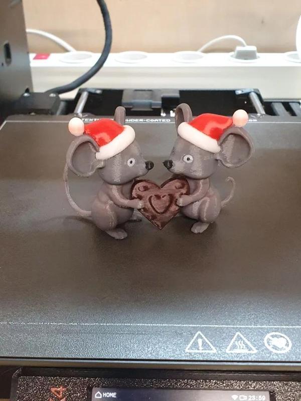 two Christmas mice holding a gingerbread cookie   