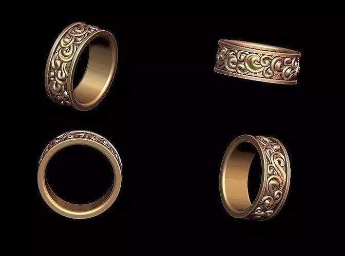 Un anillo de oro con un patron floral en el costado