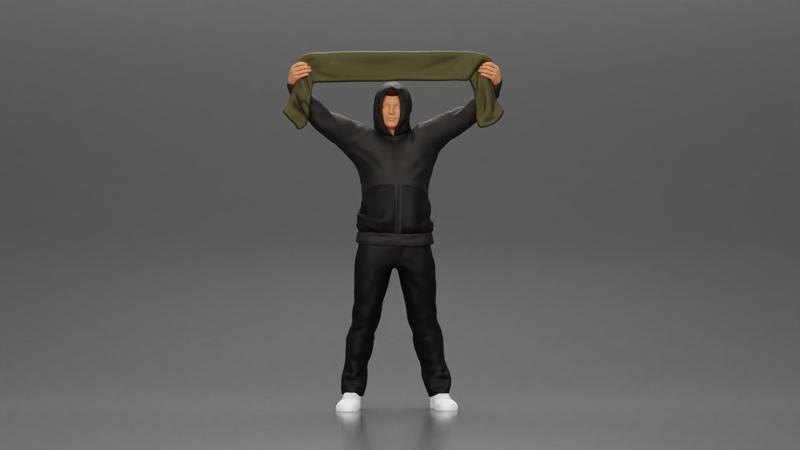 man in a hoodie supporting and holding a scarf