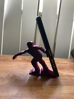 Cell phone holder in the shape of a person wakeboarding or windsurfing