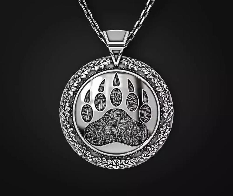 A PENDANT WITH A SLAVIC SYMBOL AND A BEAR S PAW