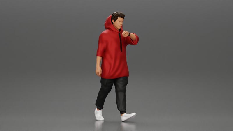Man in a long hoodie  walking and looking at his watch