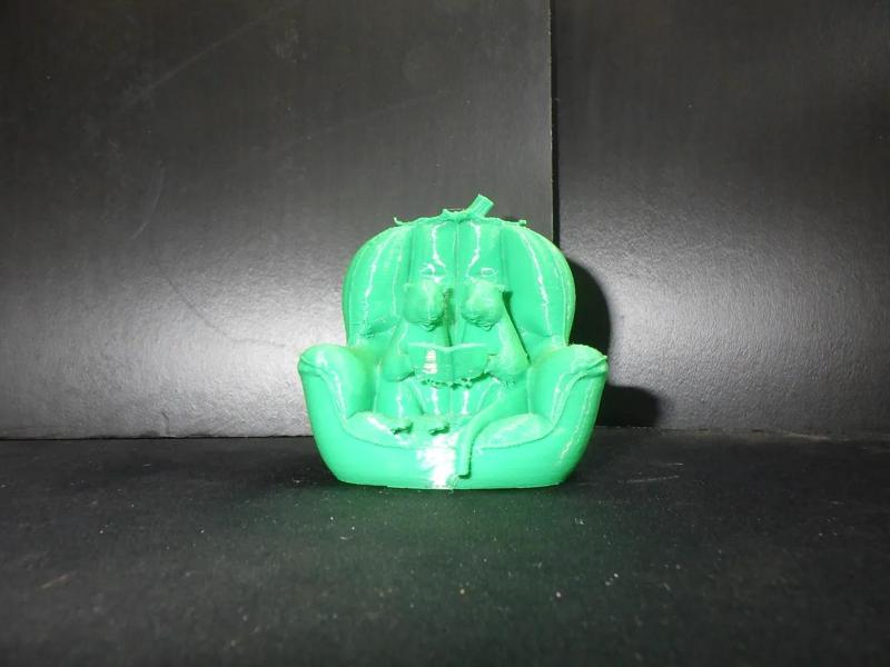 Otter chair twins sitting in a chair reading a book.   