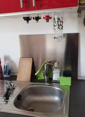 Bidon holder under cupboard