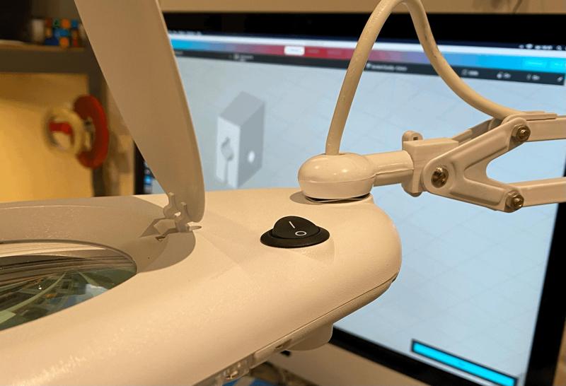 Holder for magnifying lamp head.