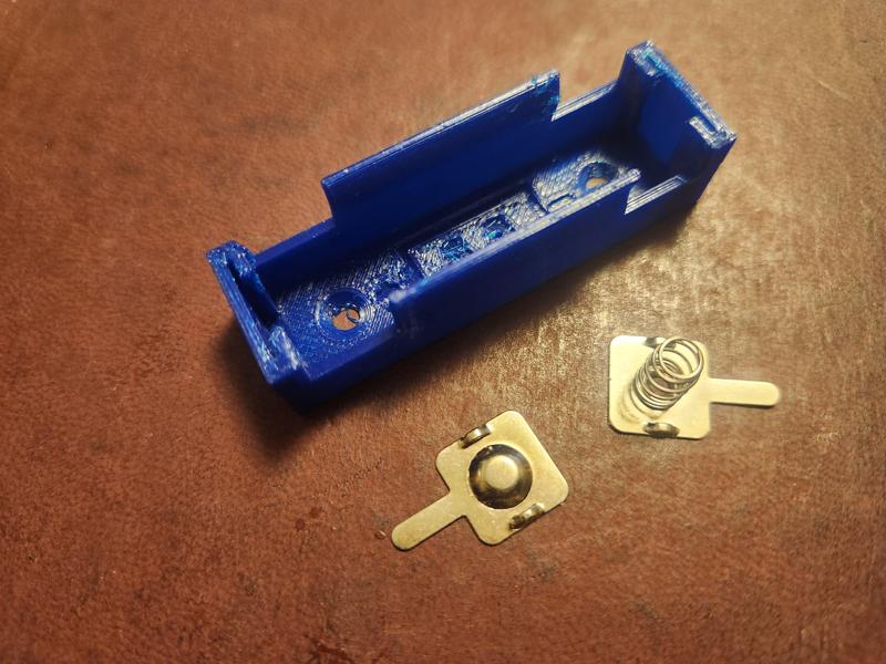 Single AA battery holder for commercial contacts