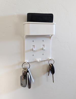 Light switch plate with key hooks and wallet pocket
