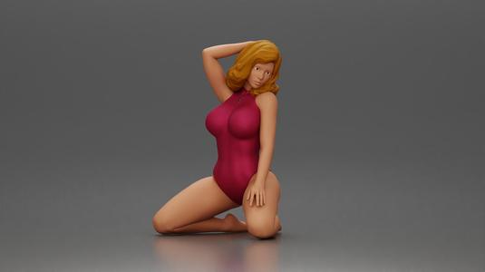Woman in red swimsuit posing gracefully on her knees on the beach