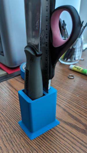 Desktop organizer for scraper, ruler, and scissors.