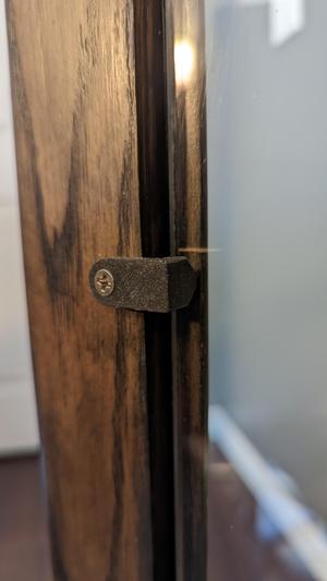 Glass retaining holder for cabinet