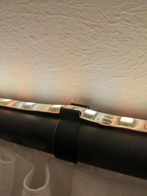 Clip for attaching LED strips to curtain rods