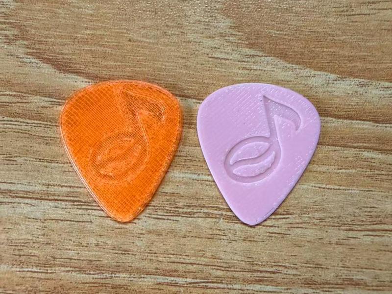 Guitar pick featuring a coffee bean and music note