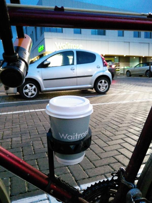 Bike cupholder for takeaway coffee. Affixes to frame on bottle cage mounts.