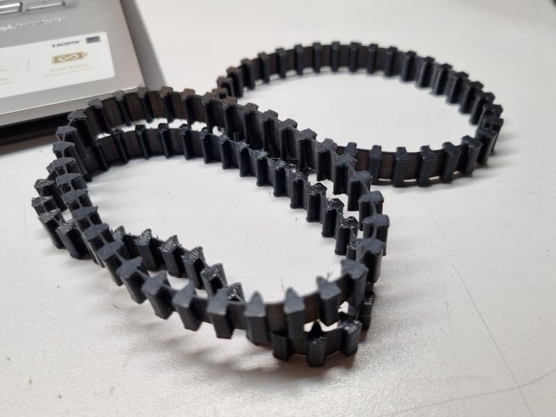 Flexible track and corresponding sprocket and idler wheel