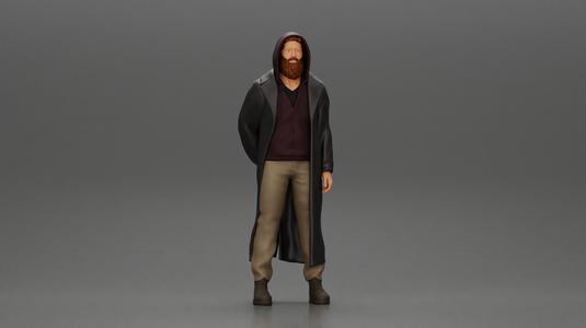 bearded man stands confidently adorned in a stylish hoodie and a flowing long coat