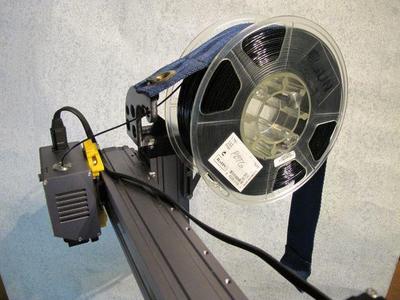 Filament guid with a bracking belt over the spool