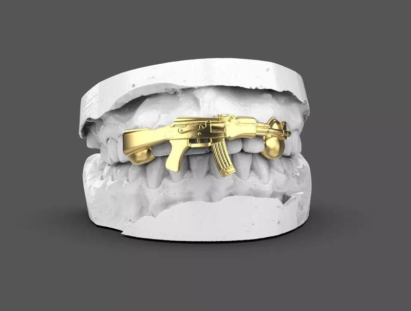 grillz gold brace with gun