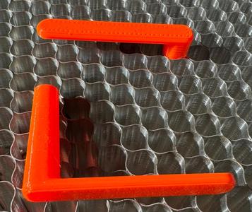 Clip to hold material on a honeycomb bed