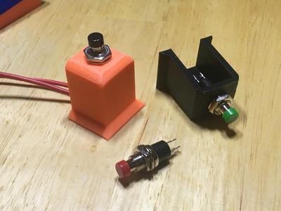 Holder bracket for a universal momentary pushbutton (The ones with 7mm wide threads) to be glued to flat surface.