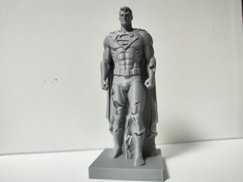 damaged standing stone sculpture of Superman