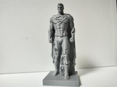 damaged standing stone sculpture of Superman