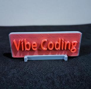 A standing plate with the text "Vibe Coding"
