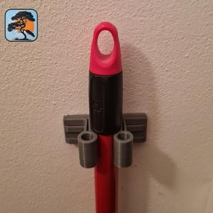 Broom handle holder compliant-mechanism.