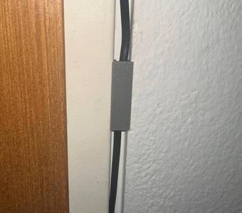 Cable duct door frame cable holder