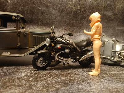 1/18 A female motorcycle rider looking at her mobile phone