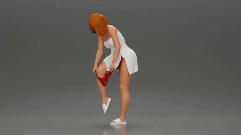 Woman in white towel lifting leg while putting on red underwear