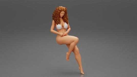 young pretty girl sitting in a chair in a bikini with long curly hair