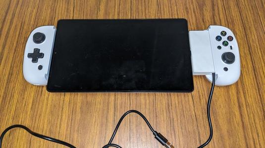 Charger slot/spacer for phone controller grip