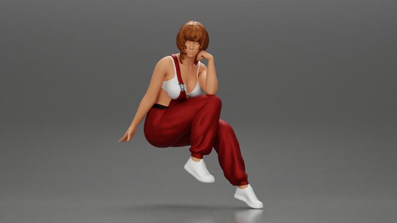 young woman sitting taking off her bib overalls