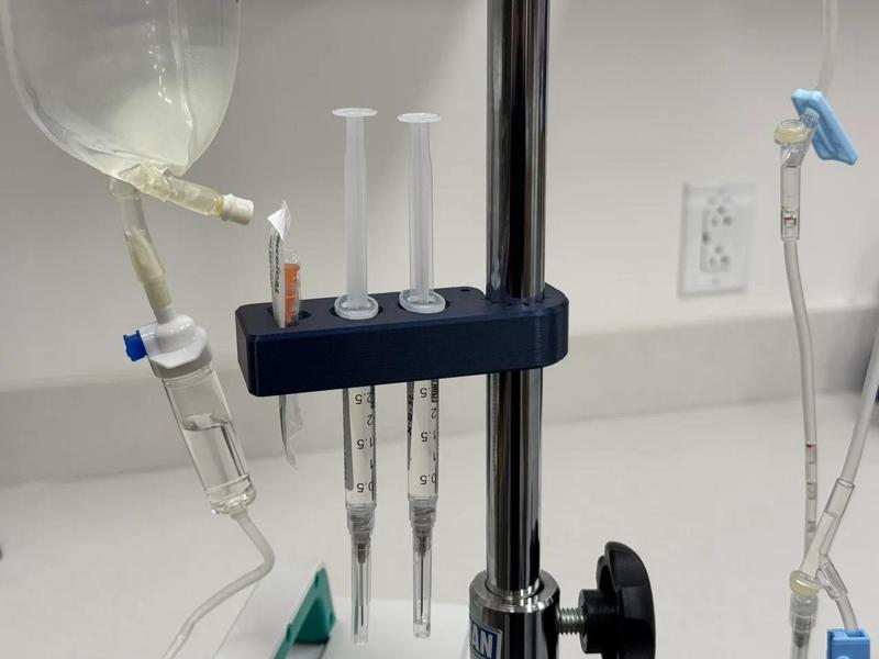 Syringe holder with IV pole clamp and needle holder   